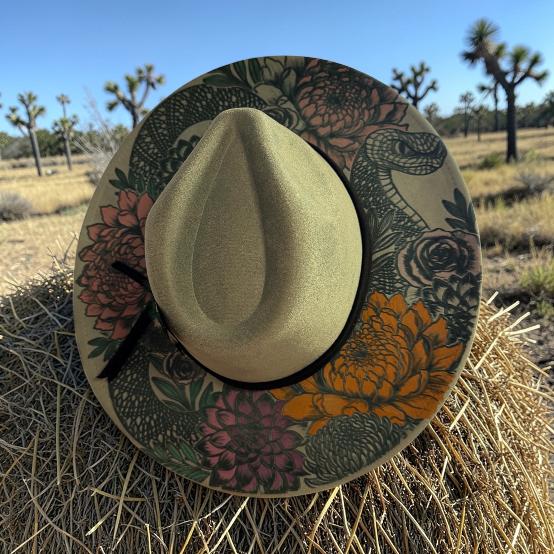 Wide brim vegan suede hat with laser burned floral and snake design with colorful flowers and feather hat band